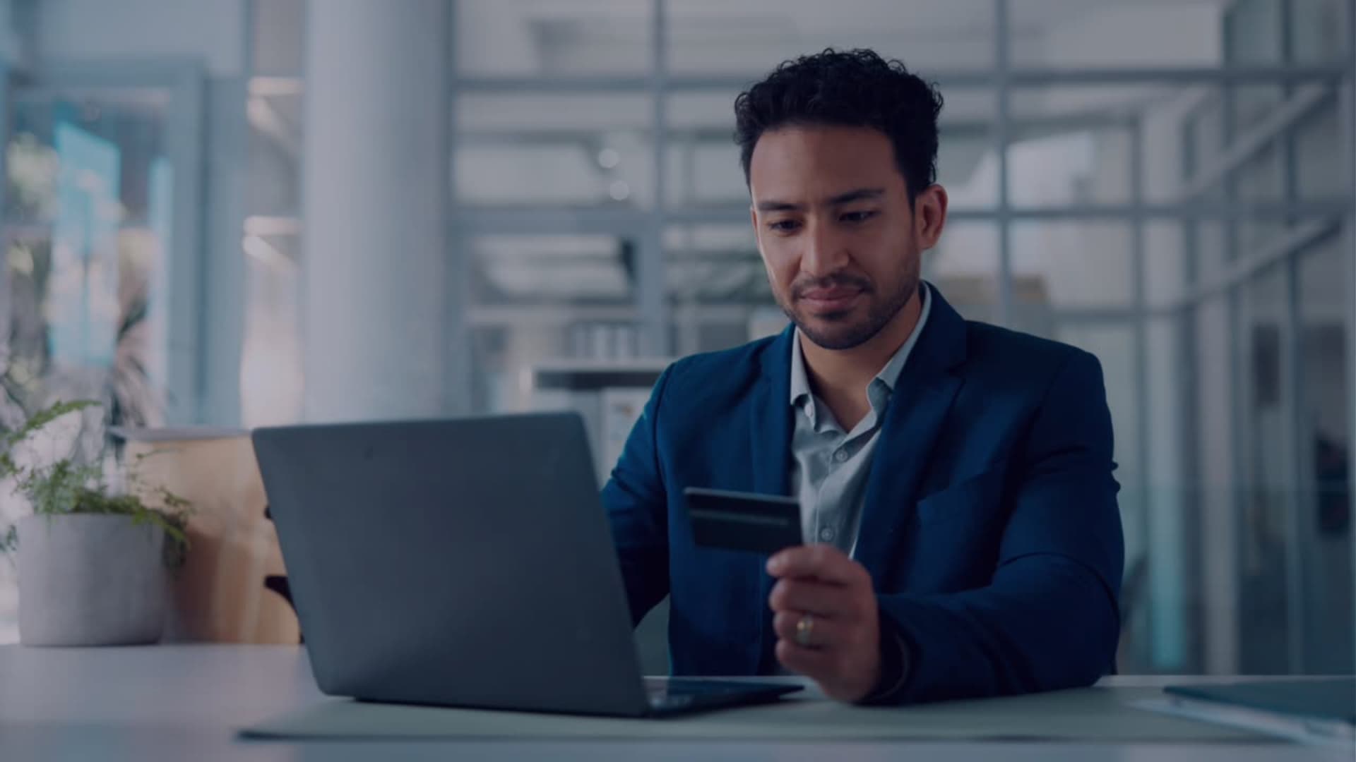 Profesional usando notebook y tarjeta en una oficina